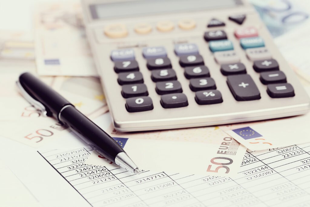 Accounting calculator with UAE dirhams and financial documents representing functional currency UAE accounting standards and currency guidelines for businesses